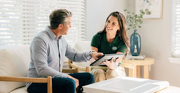 A Precision Garage Door Service technician sitting with a customer consulting on a project.