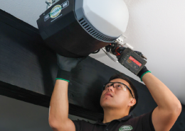 A technician installing a garage door opener.