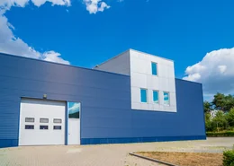 Blue and white commercial warehouse with garage door.