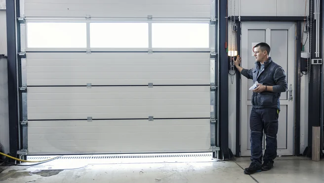 Precision Door professional inspecting sectional garage door.