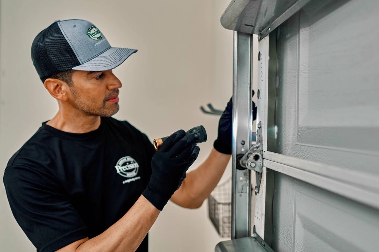 A PDS expert drilling into a garage door.