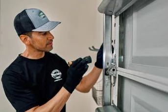 PDS professional inspecting garage door hinge.