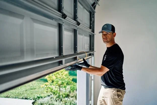 A Precision Door expert lifting a garage door.
