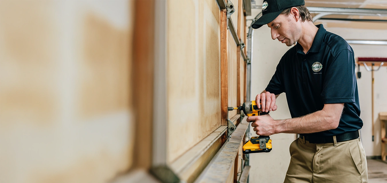 A PDS expert drilling into a garage door.