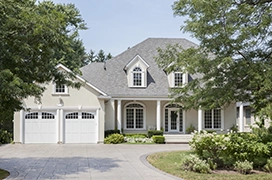 A PDS house with a double garage and trees.