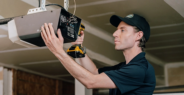 A PDS expert working on a garage door electric device.