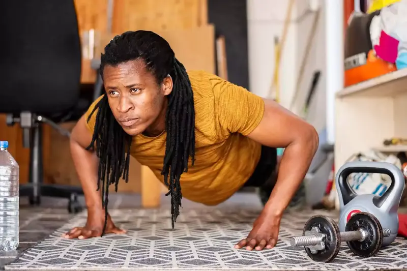 Person working out in their garage with only weights and a mat