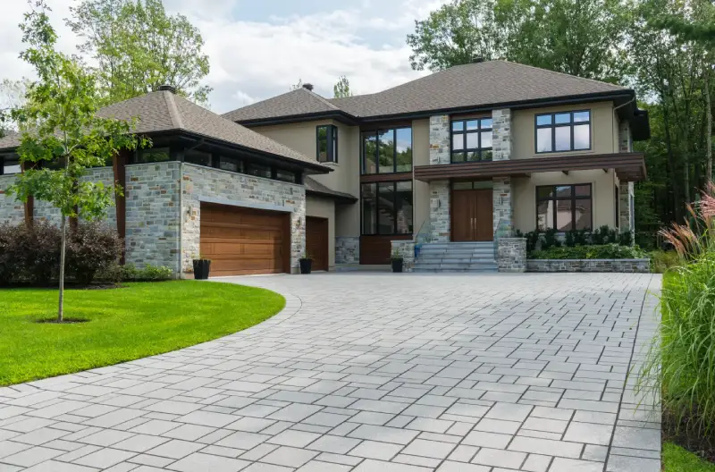 A modern home with a newly remodeled gray driveway. 