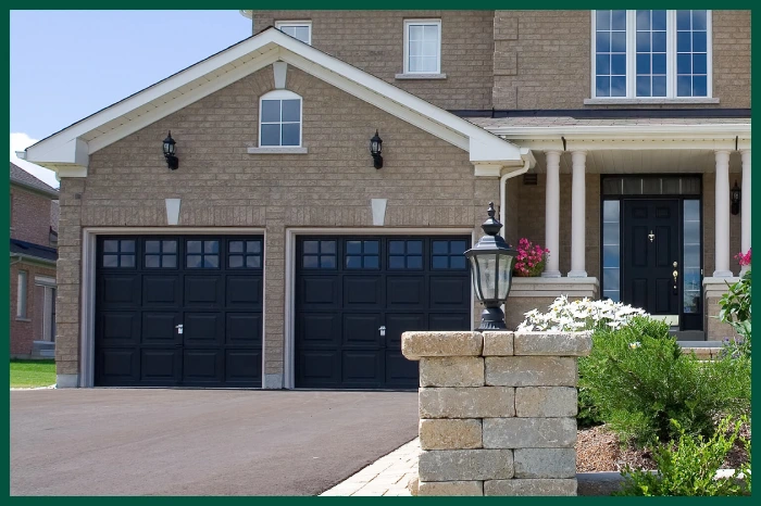 Brick house with black painted garage doors.