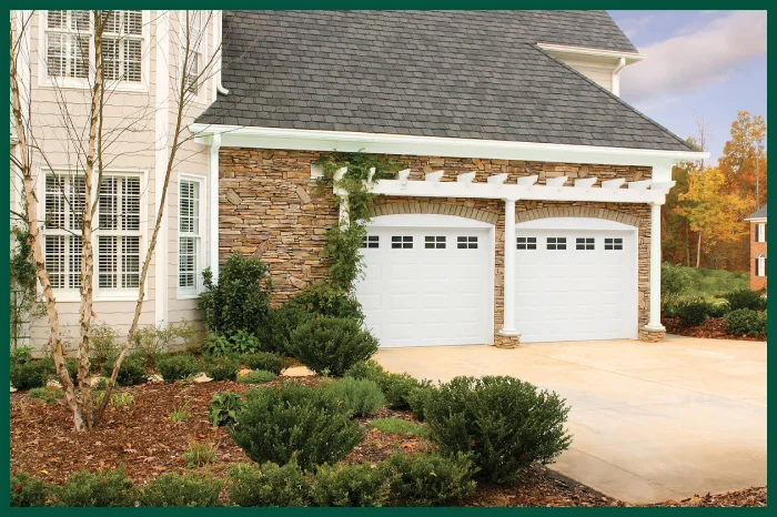 House with two white arched garage doors.