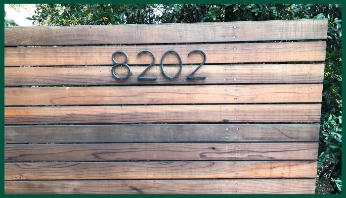 Wooden wall with modern house numbers.