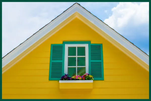 Small house with bold yellow shutters.