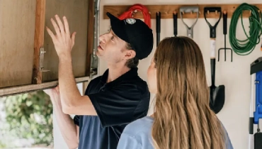 Precision Garage Door Service professional shows a customer their garage door after lubricating it.