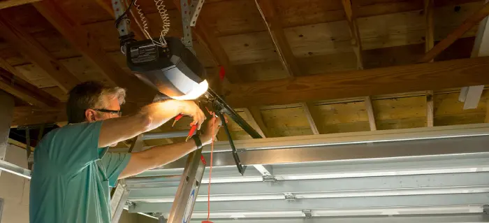 A man trying to fix a garage door.