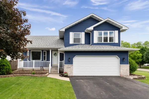 The exterior of a blue suburban house with a large white garage door. | Precision Garage Door Service of Knoxville