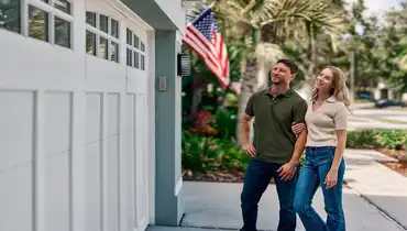 Two homeowners admiring a modern garage door by Precision Garage Door Service.