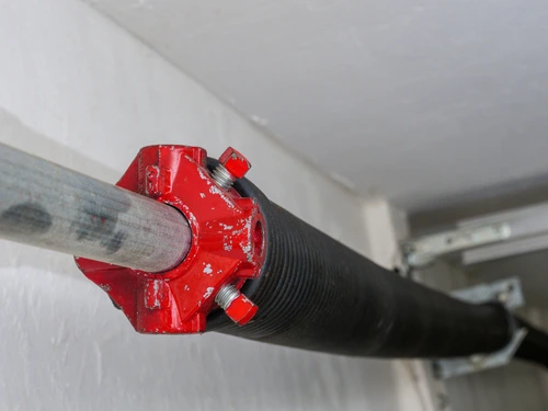 Garage door opener coiled tension spring