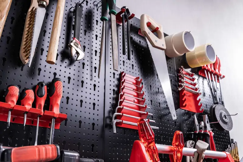 Garage storage wall with hooks, shelves, and pegs. 