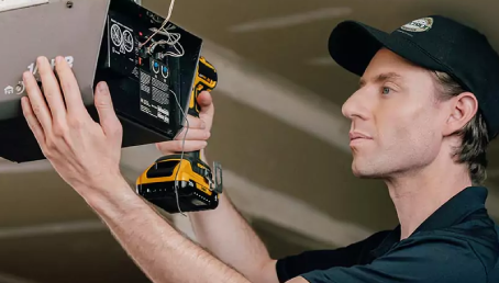 A Precision Garage Door Service professional installing a garage door opener.